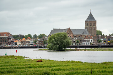 Dutch city of Kampen in Province Overijssel, scenery with the church along the IJssel river - obrazy, fototapety, plakaty