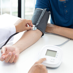 Female doctors use blood pressure monitors and stethoscope to measure pulse Diagnose the patient's disease in a modern hospital medical laboratory, Medical treatment and health care concept.