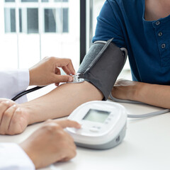 Female doctors use blood pressure monitors and stethoscope to measure pulse Diagnose the patient's disease in a modern hospital medical laboratory, Medical treatment and health care concept.
