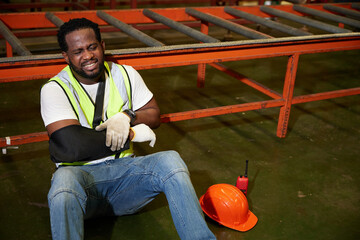 African factory workers or engineer wearing bandages splint, pain in elbow and ache in arm from...