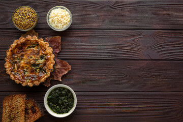 Tasty vegetables seasonal mini pies on brown rustic wooden table, top view. Space for text, copy space. 