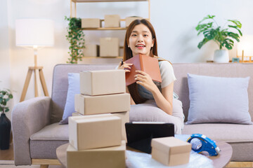 Online shopping concept, Female entrepreneur relaxes after packaging product into parcel boxes