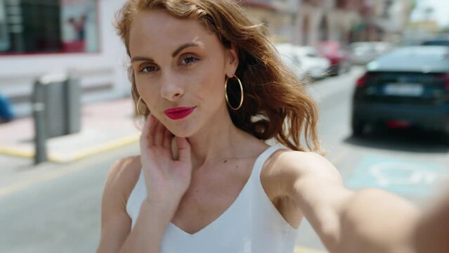 Young beautiful hispanic woman smiling confident making selfie by camera at street