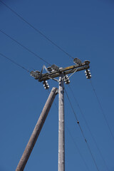 Electricity distribution pylon and power lines under blue sky