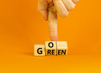 Ecology and go green symbol. Concept words Go green on wooden cubes. Businessman hand. Beautiful orange table orange background. Business ecological and go green concept. Copy space.