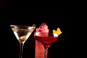 three glasses of cocktails prepared by bartender close up on presentation on black background
