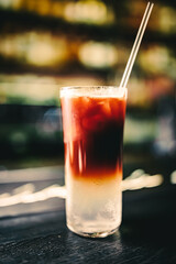 Cold drink with espresso and tonic in glass on bar