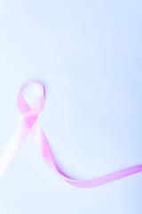 pink bow, pink ribbon symbol of fight against breast cancer isolated with space for text on blue background, international day of fight against cancer.