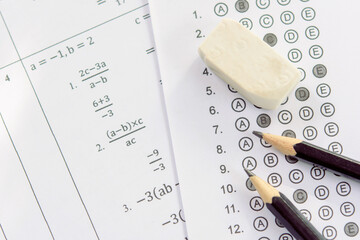 Pencil and eraser on answer sheets or Standardized test form with answers bubbled. multiple choice...