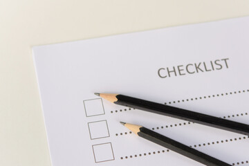 Checklist concept - checklist form paper and pencil on white table