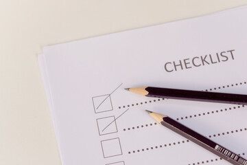 Checklist concept - checklist form paper and pencil on white table