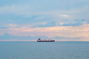 The ship sails in the Black Sea at sunset