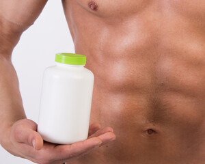 Diet and healthy lifestyle. Young attractive guy with a nice body and sports supplements.