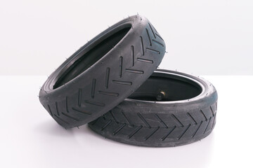 Two small scooter tire lays down on a white background. Wheel. Rubber. Black. Vehicle. Tyre. Part. Repair. Good. Excellent. Fix. Fixed. Front view. Tire threads