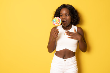 Smiling american african girl holding candy lollipop. Young cheerful woman with lollipop isolated...
