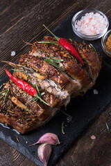 Baked pork neck with spices on a stone board