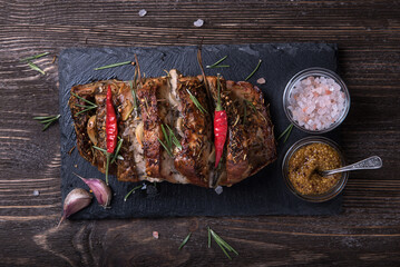 Baked pork neck with spices on a stone board