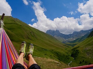 Woman relaxing in colorful hammock in the mountains of Juta valley, Chaukhi massif in the...