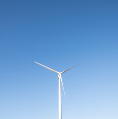 Isolated Wind Turbine against clear blue sky with copy space