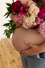 pregnant girls belly. a pregnant woman holds flowers near a pregnant belly. future mother