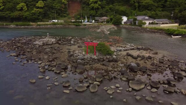 Drone shot of the Torii Gate on a land surrounded by sea in Numazu, Japan