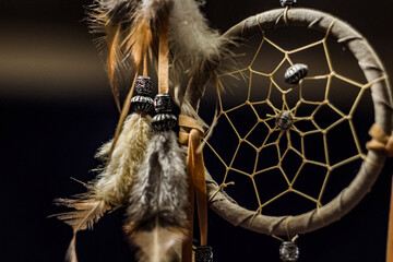 Dream catcher with feathers hanging by the bed	
