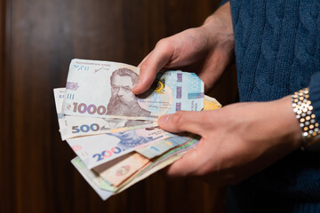 close-up on Ukrainian hryvnia held in hands. Ukrainian economy and finance