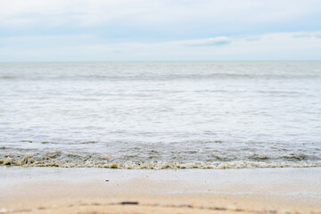 The sea and the beach are polluted with oil. A crude oil spill on the sand of a city beach. Beach oil spill impact, pollution, waste disposal. Ecological catastrophy
