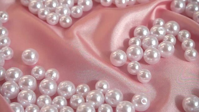 Pearls fall on silk. Slow motion.