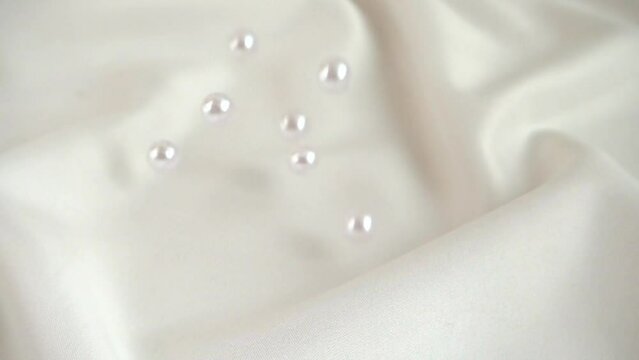 Pearls fall on silk. Slow motion.
