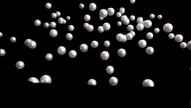 White pearls fall. Slow motion.