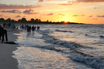 Zachód słońca nad Morzem Bałtyckim. Ludzie na plaży. Polska - Pomorze.