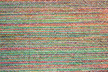 close up of woven fabric containing white, green, red, yellow and black; textile
