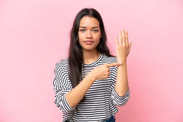 Young Colombian woman isolated on pink background making the gesture of being late