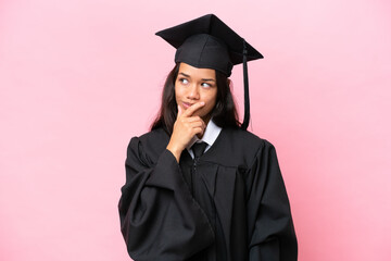 Young university Colombian woman graduate isolated on pink background having doubts and with confuse face expression