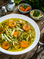 Broth - chicken soup with vegetables on wooden table
