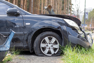 Black car after a terrible accident on the side of the road. Frontal and side impact. Life...