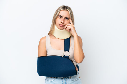 Woman with broken arm and wearing a sling isolated on white background thinking an idea