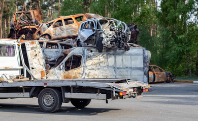 Lots of old cars ready for recycling. Car removal by tow truck. Damaged cars are waiting in a junkyard to be recycled or used for parts. The process of car recycling at a car junkyard. - obrazy, fototapety, plakaty