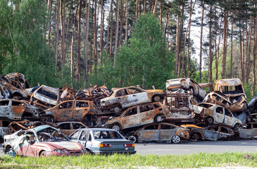 A lot of rusty burnt cars in Irpen, after being shot by the Russian military. Russia's war against Ukraine. Cemetery of destroyed cars of civilians who tried to evacuate from the war zone.