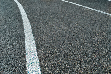 Fototapeta premium Bicycle treadmill, with white dividing strips, asphalt texture. The concept of the competition.