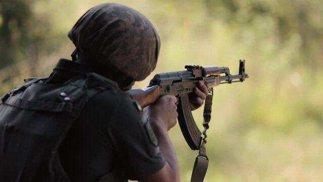 Military man in green uniform vest unloading gun with machine gun in hand, soldier with gun, officer firing machine gun, Army gunner attacking, Army war concept.