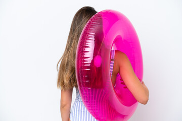 Young woman in swimsuit holding an air mattress donut isolated on white background in back position