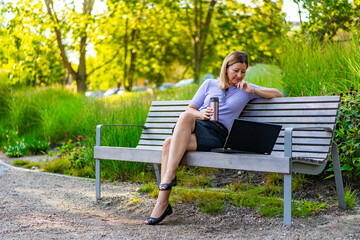 Fototapeta premium Coffee break - beautiful woman resting in city park