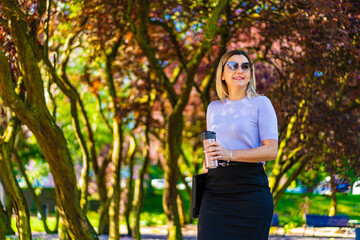 Coffee break - beautiful woman resting in city park