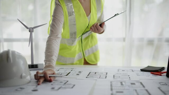 Close up of hands working and  calculations on paperworks and floor plan drawings about design architectural and engineering for houses and buildings.