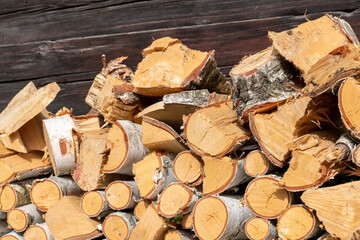 Buchenholz geschlichtet und geschnitten vor einer Holzwand