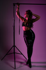 beauty woman in latex skirt on pink background, mistress