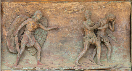 MONOPOLI, ITALY - MARCH 6, 2022: The bronze relief  Expulsion of Adam and Eve from Paradise the  on the gate of church Chiesa di Sacro Cuore by Wolfgang Stempfele from year 2002. - obrazy, fototapety, plakaty