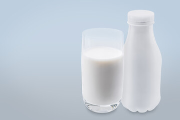 Glass of milk with a plastic bottle on a white isolated background